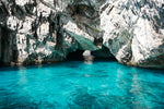 White rock cave over aqua blue water