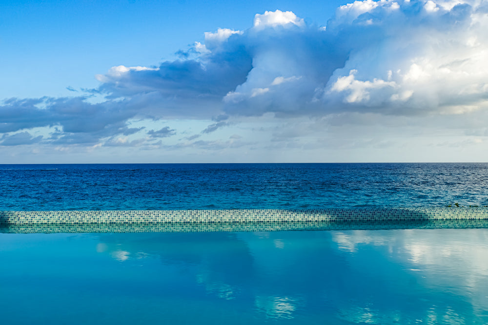 clouds reflecting on pool overlooking ocean