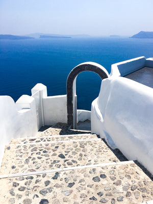 
                  
                    Stone stairs approaching archway overlooking blue ocean
                  
                